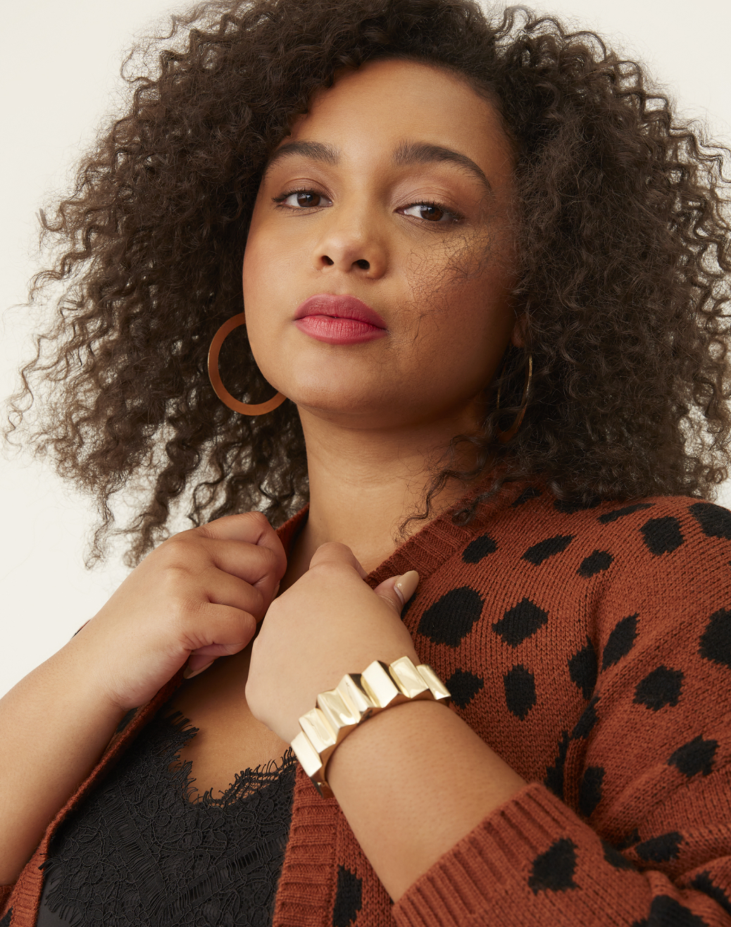 plus size woman in black cami and brown polka dotted sweater