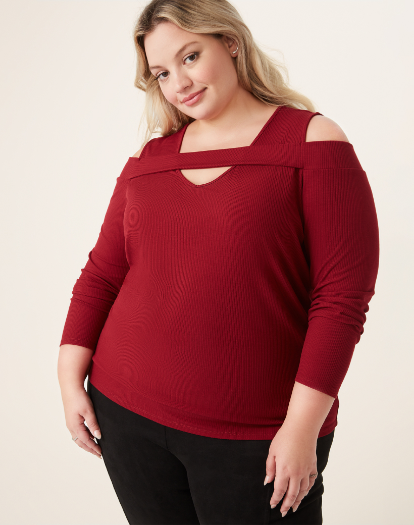 Plus size woman in red cutout long sleeve blouse and black pants